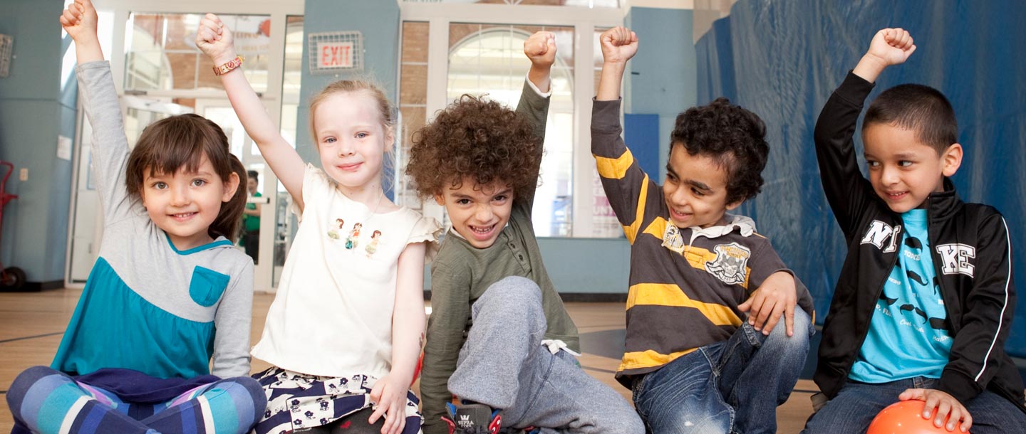 Five kids raise their fists in the air