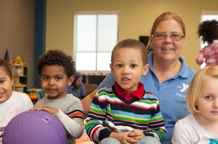 Four children and staff member in child watch room at the YMCA while you work out