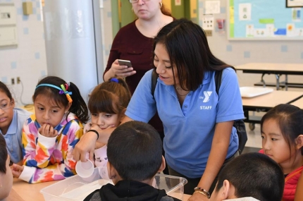 After school counselor helping students at YMCA after school program at NYC elementary school