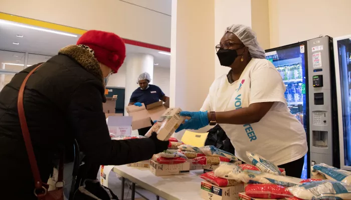 woman distributing food behind a table