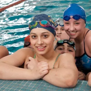 Group of Flushing Flyers swim team swimmers at indoor YMCA pool in Queens