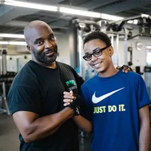 Dad and son lift weights at YMCA