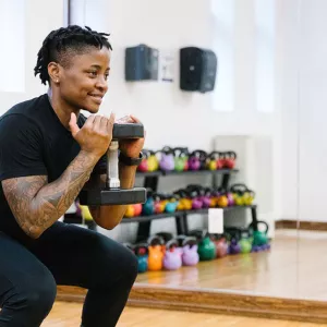 YMCA instructor demonstrates squat with weights