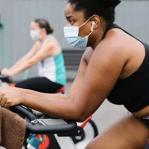 Participants in an outdoor spin class ride their spin bikes at the YMCA.