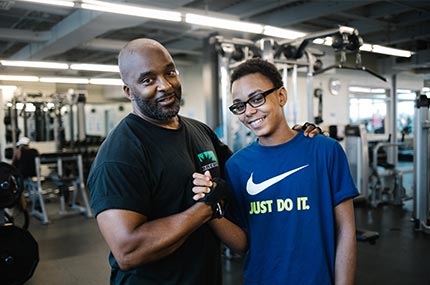 Dad and son lift weights at YMCA