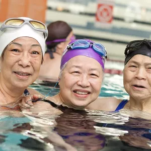 Three women in water exercise class at Chinatown YMCA pool