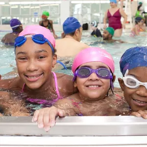 Four girls swimming at YMCA indoor pool