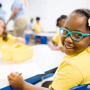 smiling young girl in yellow camp tshirt